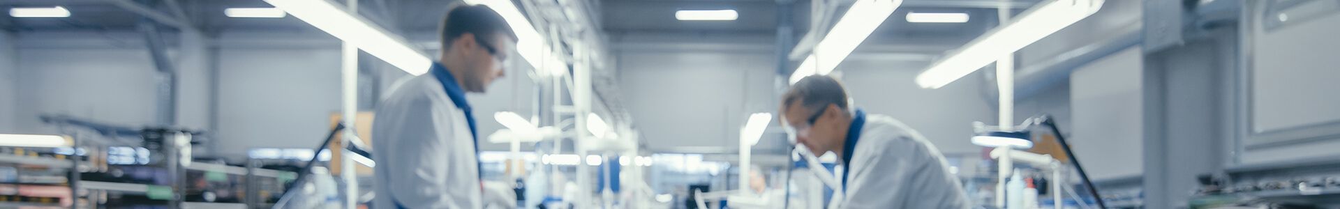 Deux hommes en blouse de laboratoire travaillent dans un laboratoire moderne dédié à la fabrication de composants électroniques