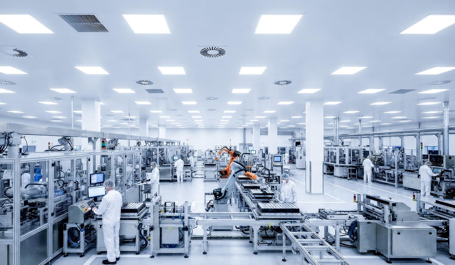 Usine où les employés utilisent des machines dans une zone blanche garantissant des conditions de production contrôlées pour les composants électroniques | Lumedic
