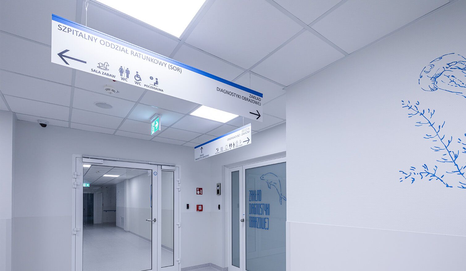 Couloir d'un établissement de santé avec des indications claires sur les murs, facilitant la circulation des patients et du personnel