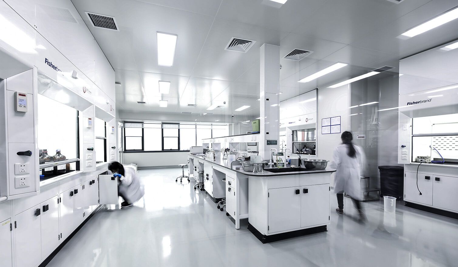 Un laboratoire pharmaceutique aux murs et armoires blancs, baigné d'une lumière vive
